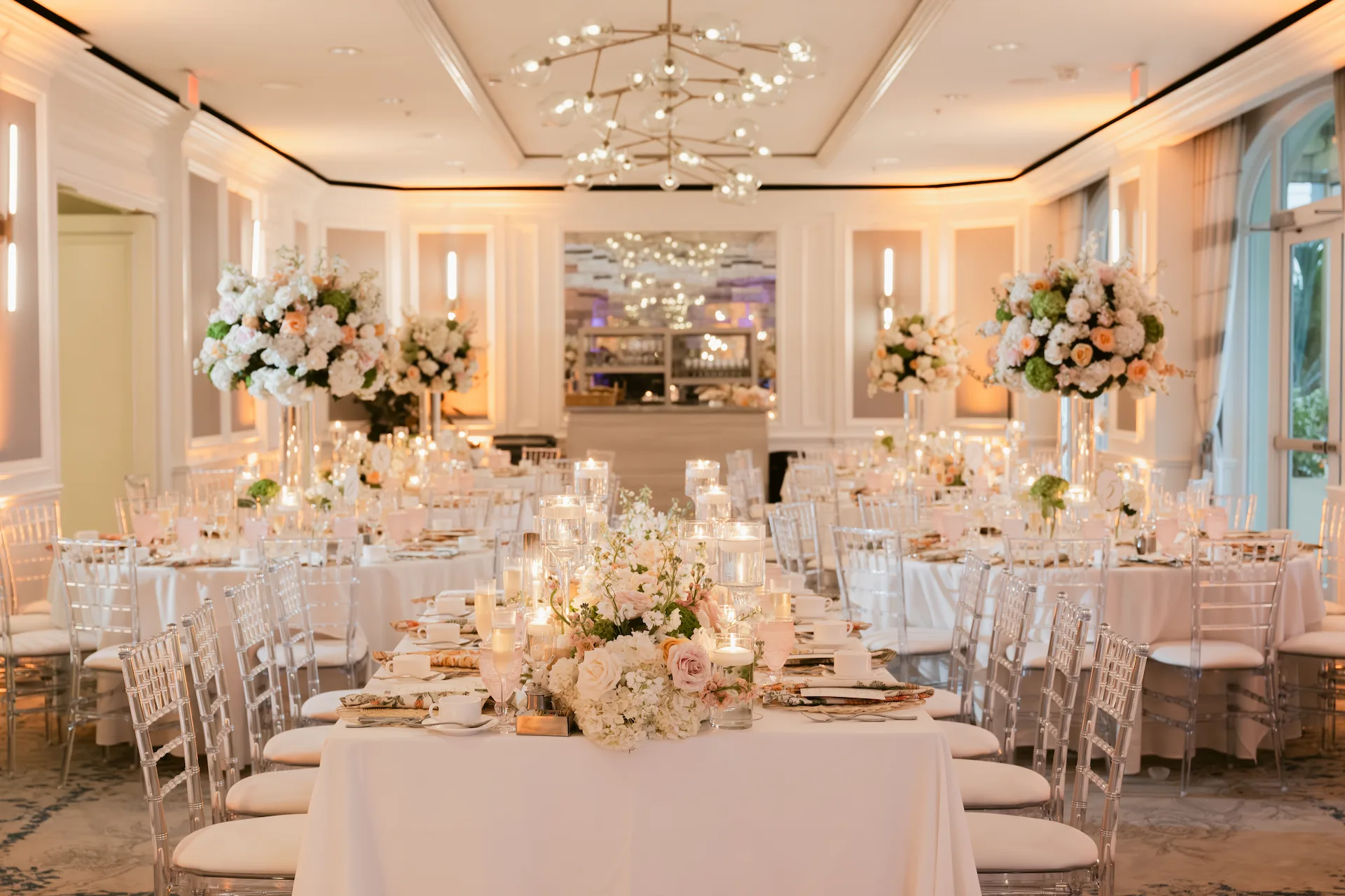 Banquet hall arranged with floral centerpieces, candles, and elegant table settings for a formal celebration.