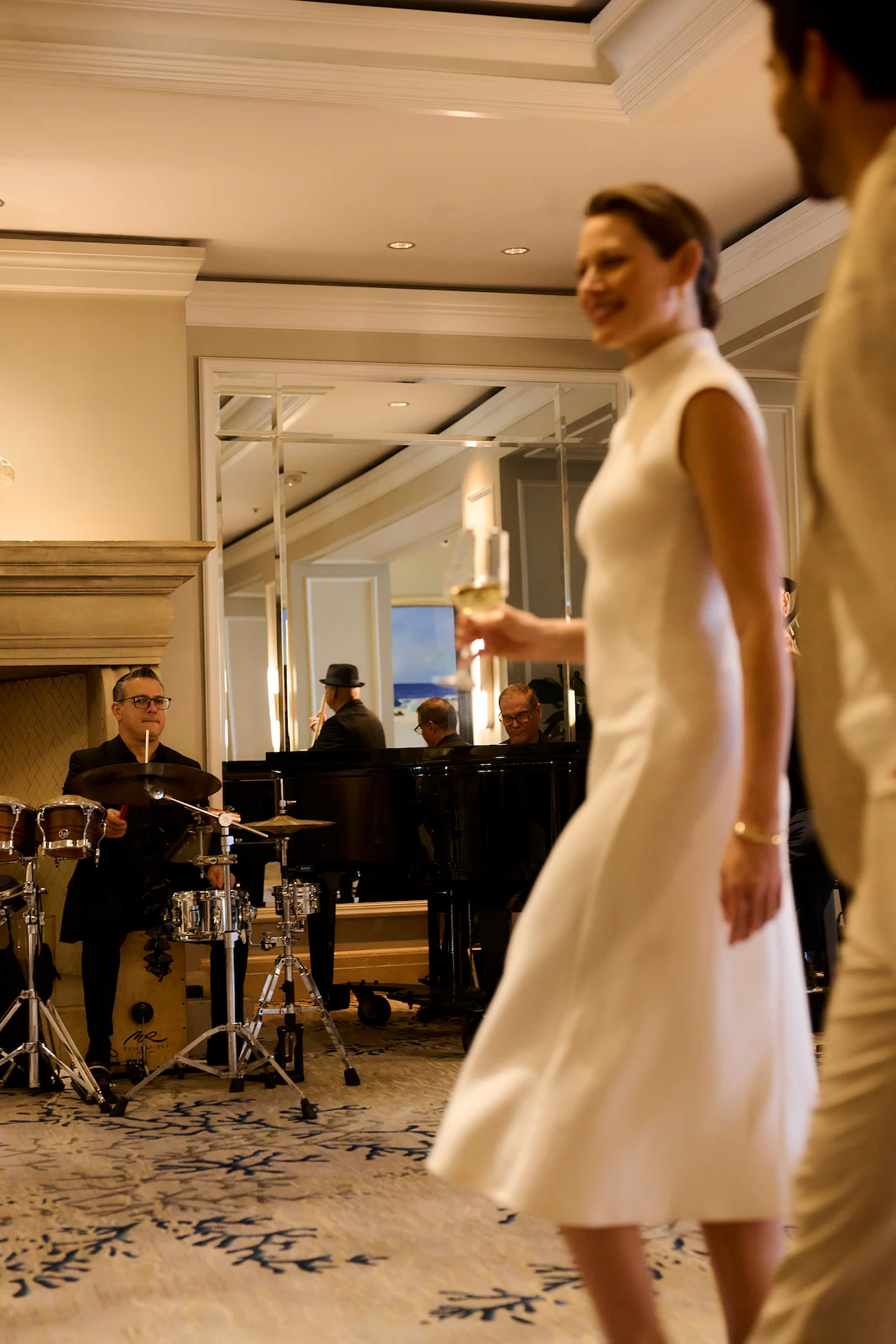 Live music band performing in an elegant lounge while guests walk by.